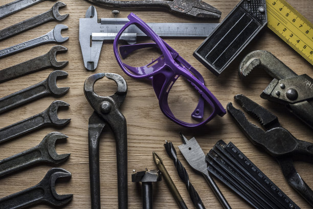 用过的手工工具和防护眼镜放在木桌上图片下载