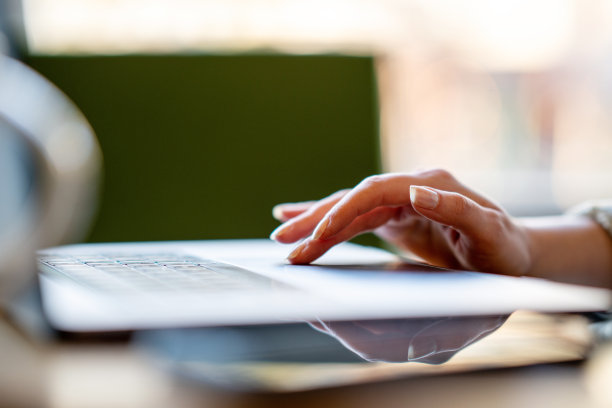 一名面目全非的女商人独自坐在家里使用笔记本电脑工作图片下载