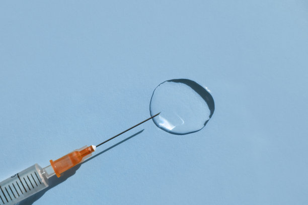 医用注射器和透明液体，蓝色背景。平铺，俯视图，复制空间。图片下载