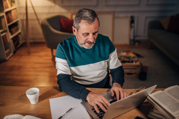 留着胡子的男作家使用笔记本电脑，工作到很晚图片下载