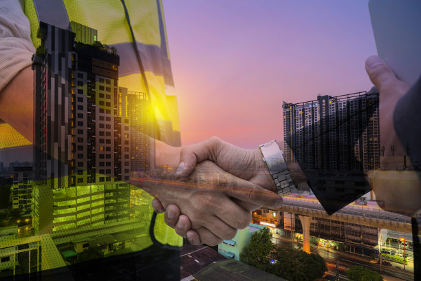 建筑师和承包商握手开工。日落时分的现代办公楼和公寓。未来建筑图片下载