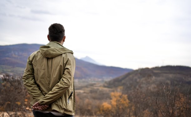 年轻的徒步旅行者在长途跋涉后休息，欣赏风景图片下载