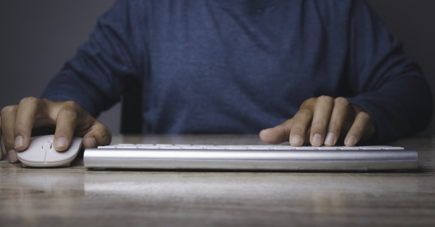 男人在键盘电脑的办公桌旁工作。图片下载