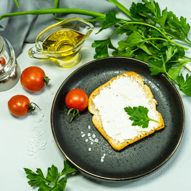 面包片，三明治，红番茄，盐瓶，绿色蔬菜。用有机农产品做早餐或零食的概念。三明治配新鲜西红柿。有选择性的重点。图片下载