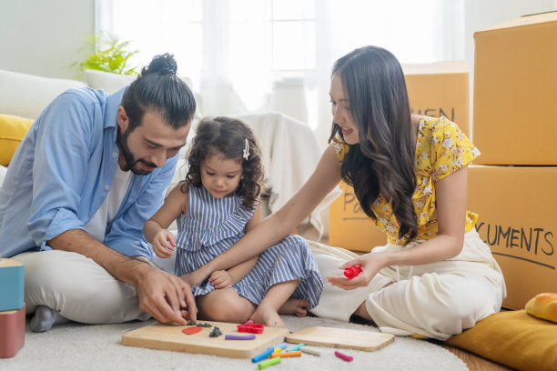 幸福一家人坐在休闲客厅玩橡皮泥的模具，女儿和她的父母一起用柔软的彩色粘土面团雕刻人物，带着快乐的微笑看着照顾图片下载