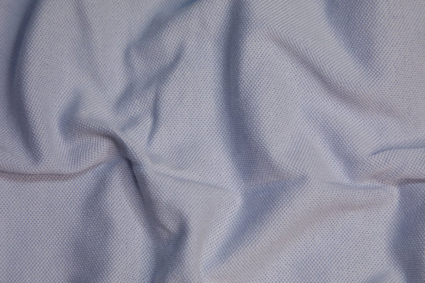 浅蓝色织物背景。浅蓝色的布波浪背景纹理。浅蓝色织物布纺织材料。图片下载