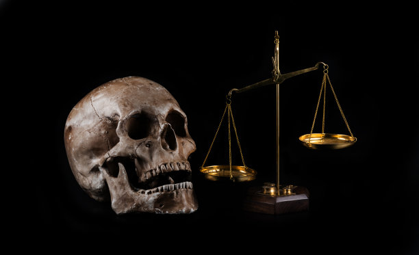 金色鳞片和黑色背景上的人类头骨图片下载