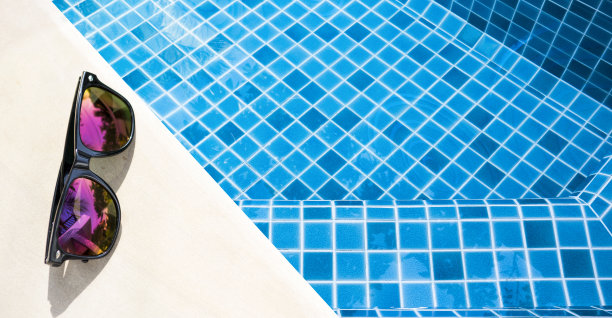 太阳镜在游泳池边图片下载