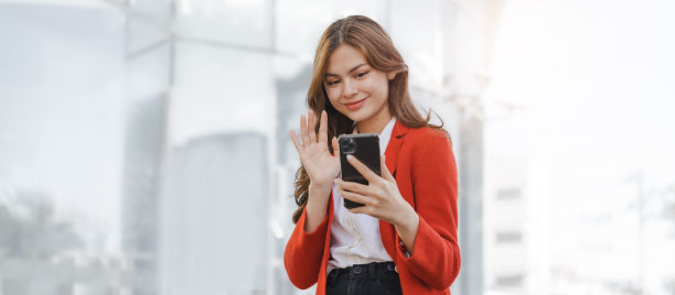 用手机，打电话，微笑着年轻的亚洲商业女性领导企业家在户外城市街道行走。图片下载