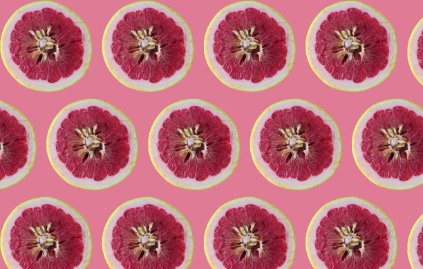 粉红背景上孤立的柚子片。柑橘，健康营养理念理念。图片下载