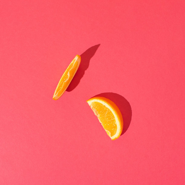 橘色切片，粉红色背景。最小的夏日水果或有机食品概念。图片下载