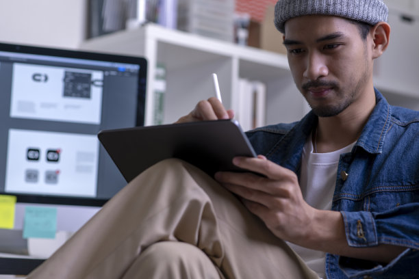 年轻的亚洲男性设计师在数码平板上画画。图片下载