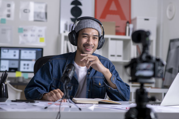 年轻的亚洲男性平面设计师为在线课程录制视频内容。图片下载