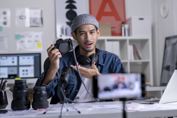 年轻的亚洲男性摄影师设计师为在线课程录制视频内容。图片下载