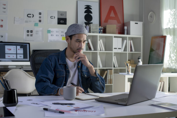 亚洲男性平面设计师在办公室工作。图片下载