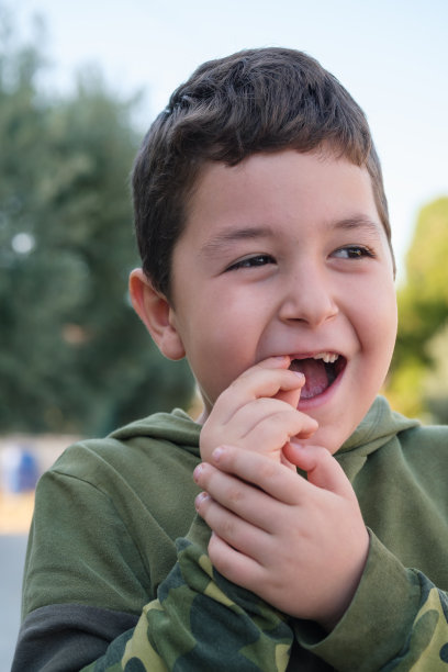小男孩炫耀牙齿缺了，男孩在户外没有上两颗牙，脸上疼痛。图片下载