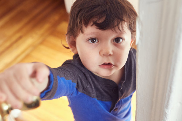 看到一个蹒跚学步的孩子打开房间的门图片下载