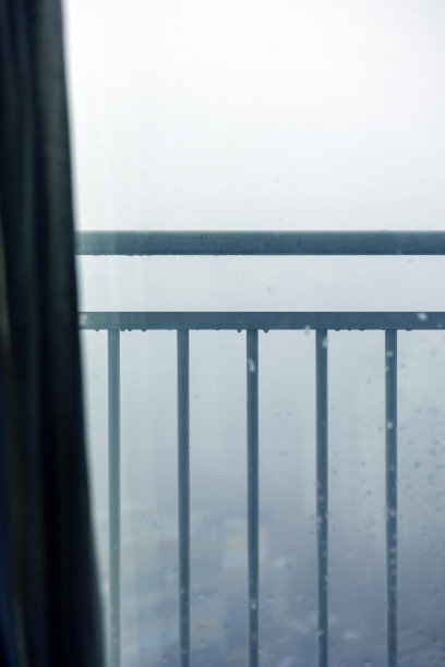 透过栏杆可以看到大雾笼罩的城市景色图片下载
