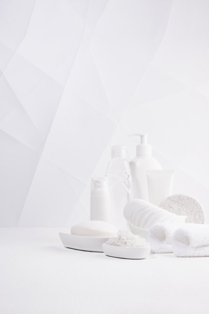 现代极简主义柔光白色浴室，配有化妆品和洗漱用品-毛巾，浴盐，海绵放在白色桌子上，用于身体和皮肤护理，以现代几何风格，复制空间，垂直。图片下载