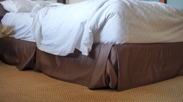 凌乱的床，枕头和毯子在房子里图片下载