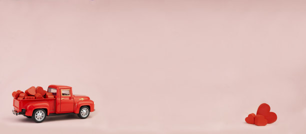 红色汽车在粉红色的背景与心脏在身体，空间复制。图片下载