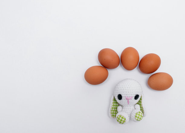 复活节的概念。针织复活节兔子或兔子与鸡蛋的白色背景。照片图片下载