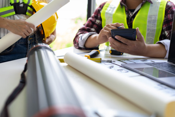 建筑师和工程师同事就建筑项目的蓝图规划思想进行头脑风暴设计工作。建设工程设计检验员队伍。图片下载