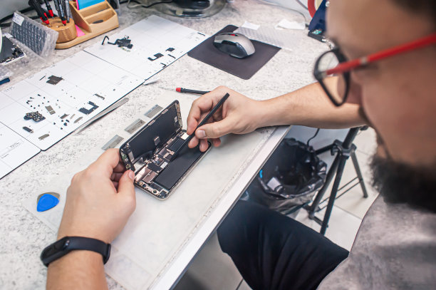 电子维修车间，技术人员被工具和设备包围着。图片下载