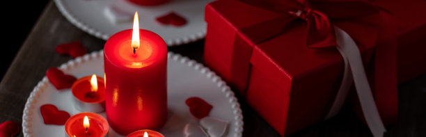 情人节庆祝活动。红色燃烧的蜡烛，爱心，礼品盒，明信片在黑暗的木制背景。节日快乐。餐桌装饰喜庆，气氛浪漫图片下载