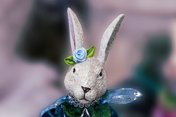 复活节兔子雕像的头和肩膀-穿着闪亮的衣服-抽象模糊的背景和复制的空间图片下载