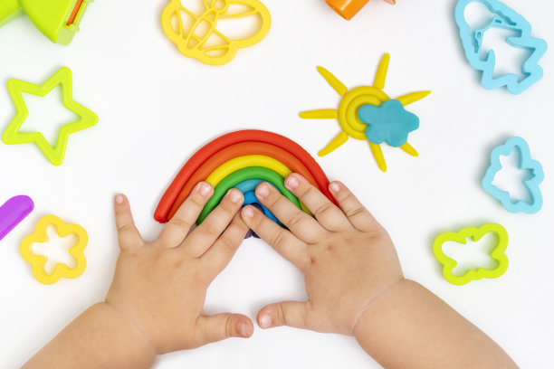 孩子的手玩着五颜六色的橡皮泥。女孩造型造型玩面团。图片下载