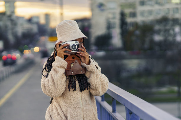 一名非洲裔美国妇女来到一个大城市，她到一个陌生的城市度假。她正在照相机前拍照图片下载