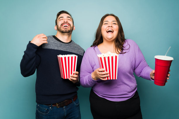 兴奋有趣的情侣在看电影时大笑图片下载