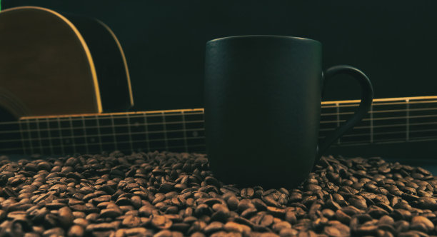 木吉他，黑咖啡杯和烤咖啡豆铺在桌上，温暖而复古图片下载