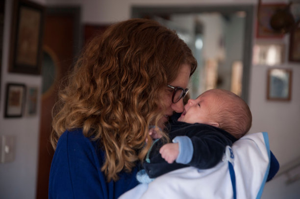 姜黄色的母亲抱着她的孩子在房间里图片下载