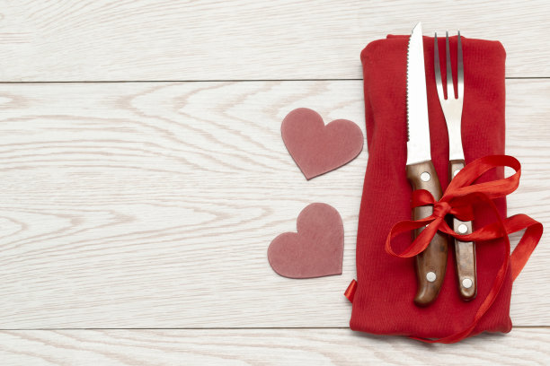 情人节，妇女节的餐桌上有心形，餐具和白色背景的红色餐巾。浪漫晚餐，爱情，约会的概念。俯视图平面复制空间图片下载
