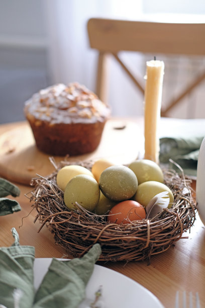 特写的一窝树枝里面有黄色，绿色和浅绿色的复活节彩蛋图片下载