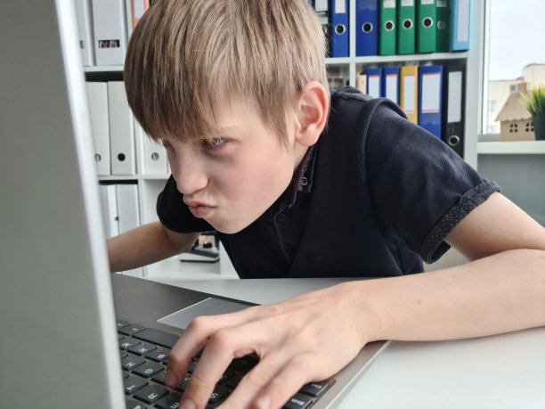 惊讶的少年兴奋地看着笔记本电脑屏幕图片下载