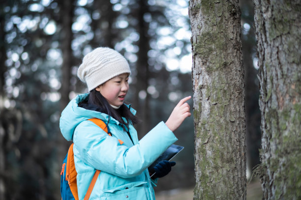 亚洲初中生在森林里观察树木并做记录图片下载
