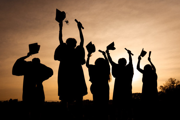 近景大学毕业生在剪影日落的后景组图片下载