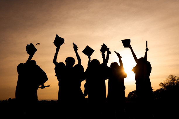 近景大学毕业生在剪影日落的后景组图片下载