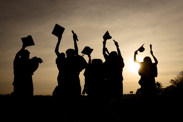 近景大学毕业生在剪影日落的后景组图片下载