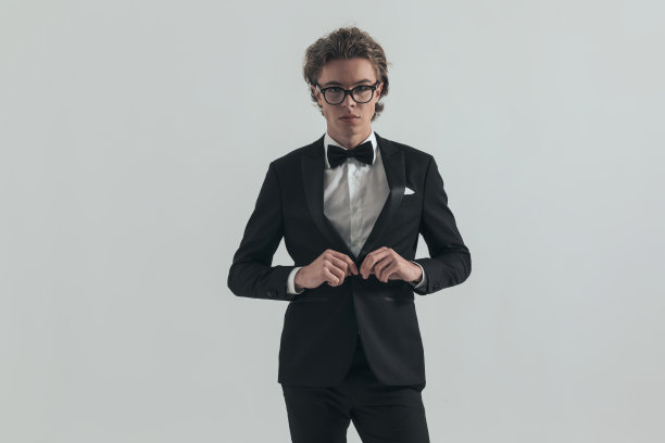 自信优雅的男子与眼镜解开黑色燕尾服纽扣图片下载