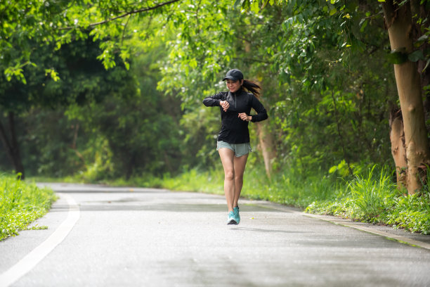 健康女性在户外道路上慢跑、跑步和锻炼。亚洲跑步者健身馆与健身课程，自然公园背景。健康与生活理念图片下载