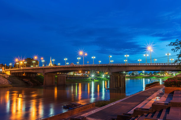 美丽的灯光在公园的道路上放松散步，慢跑或骑自行车和锻炼，晚上在泰国彭萨洛市的大桥(Naresuan桥)上的南河。图片下载