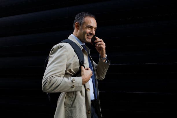 拍摄一个商人走在外面，在城市里打电话图片下载