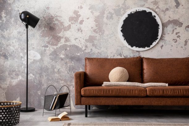 阁楼风格的现代公寓与模拟海报框架，棕色沙发现代黑灯，圆枕头，书籍，篮子和个人配件。家居装饰。模板。图片下载