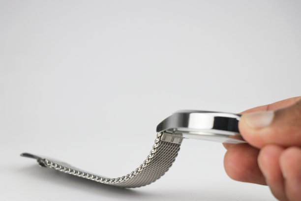 手表，表链由针织金属或不锈钢制成，手持白色背景图片下载