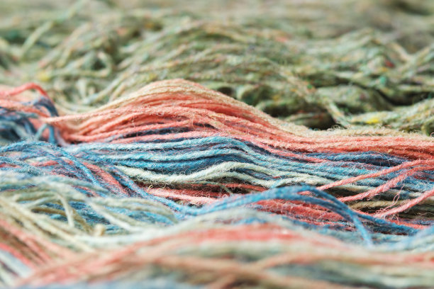 丝线由天然有机羊毛制成。特写,宏。两束松开的绿色和彩虹色针织纱。图片下载