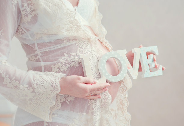 孕妇深情地拥抱肚子图片下载